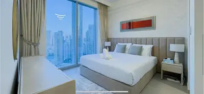 a bedroom with a large bed and a large window at Downtown Gem Apt, Burj View Bliss in Dubai