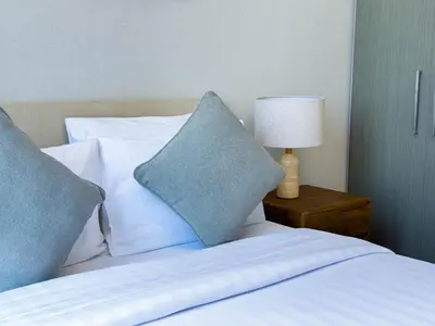 a bed with pillows and a lamp on a table at Downtown Gem Apt, Burj View Bliss in Dubai
