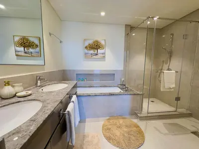 a bathroom with two sinks and a shower at Downtown Gem Apt, Burj View Bliss in Dubai
