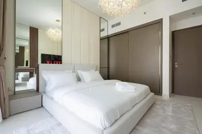 a bedroom with a large white bed and a mirror at KeyRock - Palm View Apt with Pool & Gym Access in Dubai