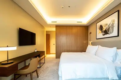 a hotel room with a bed and a desk and a television at Venetian - Sky 3BR - Address Opera with Burj & Fountain views in Dubai