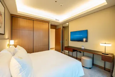 a hotel room with a bed and a television at Venetian - Sky 3BR - Address Opera with Burj & Fountain views in Dubai