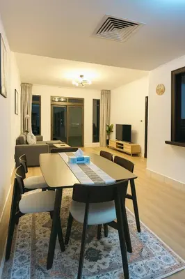a dining room and living room with a table and chairs at 5 Star Burj Khalifa View Spacious 2BR Next to Dubai Mall in Dubai
