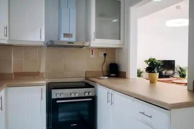 a kitchen with white cabinets and a black oven at Top Holiday Location - Canal View - Beach Access in Dubai