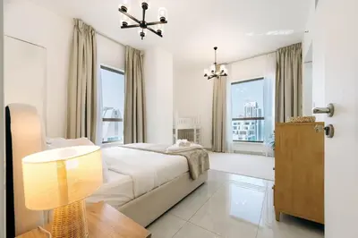 a bedroom with a bed and a large window at Top Holiday Location - Canal View - Beach Access in Dubai