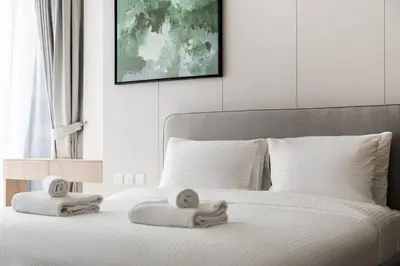 a bedroom with a bed with two towels on it at SettlerHomes - Liv Marina Luxe With Gym, Pool, Sauna in Dubai