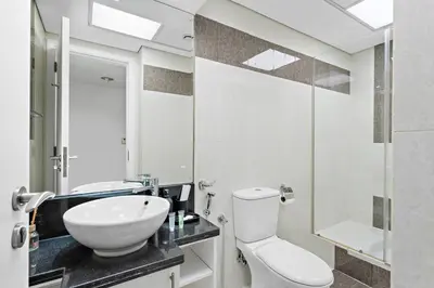 a bathroom with a white toilet and a sink at Beautiful Studio Prime location Pool & Gym in Dubai
