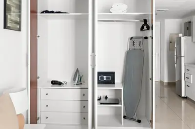 a kitchen with white cabinets and a refrigerator at Beautiful Studio Prime location Pool & Gym in Dubai