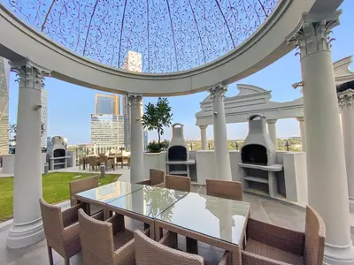 a dining room with a glass table and chairs at Beautiful Studio Prime location Pool & Gym in Dubai