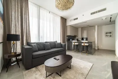 a living room with a couch and a table at SettlerHomes - Lux 20F Stay With Gym, Pool & Cinema in Dubai