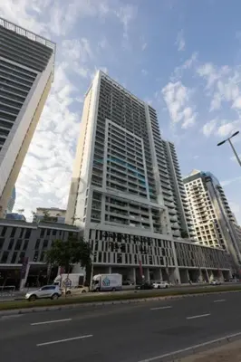 a tall white building on the side of a street at City View with Balcony Next to Dubai Water Canal, Walking Distance to Marine Transport Station, Easy Downtown Access, Reva Residences, Business Bay by Deluxe Holiday Homes in Dubai