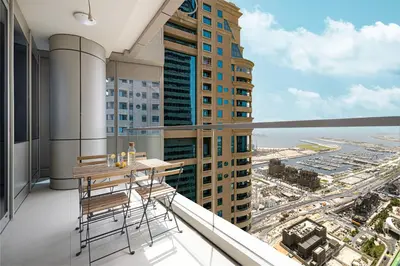 a balcony with a table and chairs on a building at Sea & City View Apartment Dubai Marina - Ravello Living in Dubai