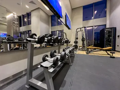 a gym with a row of dumbbells on a wall at Luxury Redefined 1BR Apartment in Emaar 5242 in Dubai