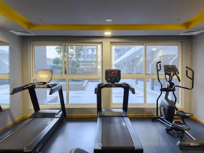 a gym with two tread machines in a room with a window at Comfortable Studio Living in Dar Al Jawhara, JVC in Dubai