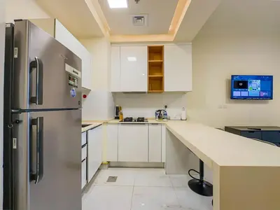 a kitchen with a stainless steel refrigerator and white cabinets at Comfortable Studio Living in Dar Al Jawhara, JVC in Dubai
