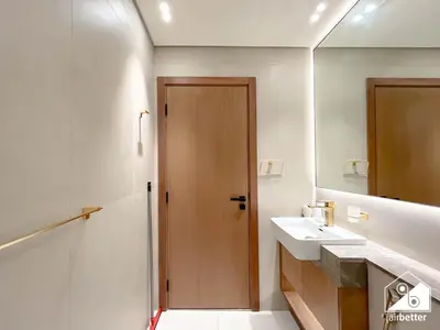 a bathroom with a sink and a wooden door at Luxury 1BR l Balcony, Pool, Gym & Prime Location in Dubai