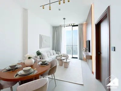 a living room with a table and a couch at Luxury 1BR l Balcony, Pool, Gym & Prime Location in Dubai