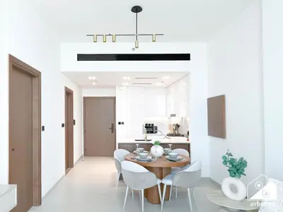 a kitchen and dining room with a table and chairs at Modern 1BR in JVC l Pool, Gym, Parking in Dubai