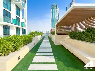 a walkway in the middle of a building with plants at Modern 1BR in JVC l Pool, Gym, Parking in Dubai