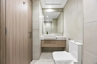 a bathroom with a toilet and a sink and a mirror at Elite Escape - Getaway in Azizi Riviera 26 in Dubai