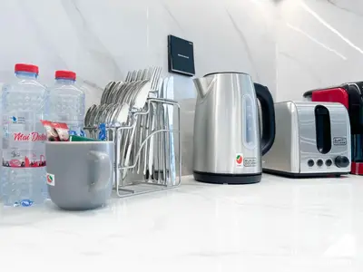 a kitchen counter with bottles of water and appliances at Dubai JVC 1BR l Stylish Stay with Top Amenities in Dubai