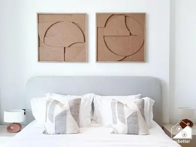 a bedroom with a white bed with two pictures on the wall at Dubai JVC 1BR l Stylish Stay with Top Amenities in Dubai