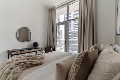 a bedroom with a large bed with a large window at The Smart Concierge - Marina Wharf in Dubai