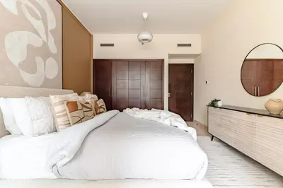 a bedroom with a large white bed and a mirror at The Smart Concierge - Burj Views in Dubai
