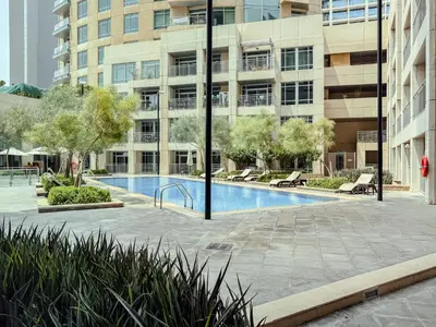 a swimming pool in front of a large building at The Smart Concierge - Burj Views in Dubai