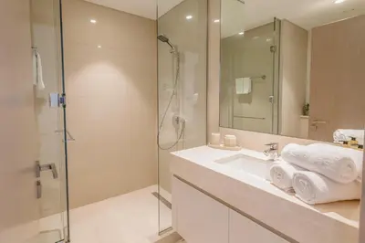 a bathroom with a sink and a shower at Sarora One - Japandi-Inspired 2-Bedroom Apartment in Act One, Downtown Dubai with Balcony & Burj Khalifa View in Dubai