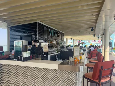 a view of a restaurant with a counter and chairs at Seven Palm Jumeirah Studio - Private Beach Access in Dubai