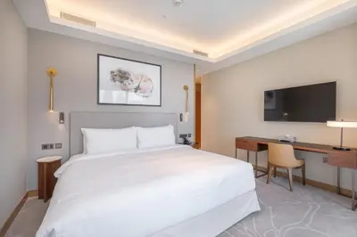 a bedroom with a large white bed and a desk at Shukr شكر - Luxury 3BR with Panoramic Burj Khalifa & Fountain Views - Address Residence Dubai Opera - 2 Min Walk to Dubai Mall in Dubai