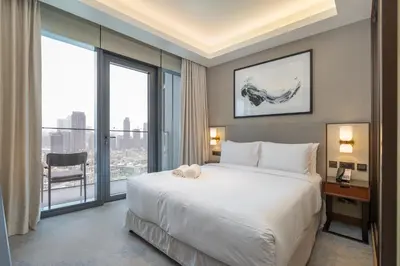a bedroom with a bed and a desk and a large window at Shukr شكر - Luxury 3BR with Panoramic Burj Khalifa & Fountain Views - Address Residence Dubai Opera - 2 Min Walk to Dubai Mall in Dubai