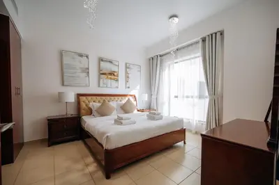 a bedroom with a bed and a large window at Top Holiday Location - Walk to Beach - Free Pool & Gym in Dubai