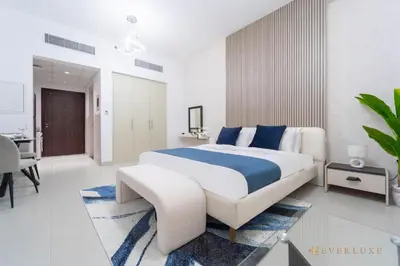 a large bedroom with a large bed and a desk at Cozy Studio With Style Midtown Retreat - Impz in Dubai