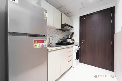 a kitchen with a refrigerator and a washing machine at Cozy Studio With Style Midtown Retreat - Impz in Dubai