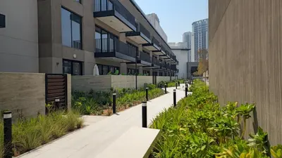 a sidewalk in front of a building with plants at Brand New 2BR -Spacious in Dubai