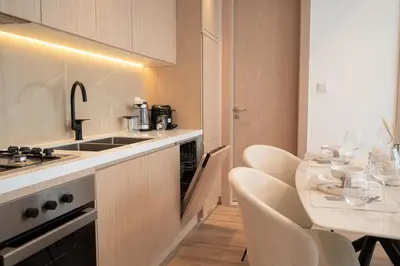 a kitchen with a sink and a table with chairs at Brand New 2BR -Spacious in Dubai