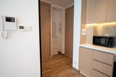a room with a kitchen with a microwave and a hallway at Brand New 2BR -Spacious in Dubai