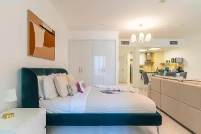 a bedroom with a bed with a green head board at The Smart Concierge - Murjan in Dubai