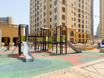 a playground with slides in a city with tall buildings at The Smart Concierge - Murjan in Dubai