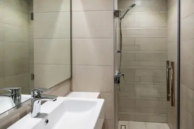 a bathroom with two sinks and a shower at Upscale 1 Bedroom Apartment - Azizi Riviera 27 - Allsopp & Allsopp in Dubai