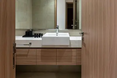 a bathroom with a white sink and a mirror at Upscale 1 Bedroom Apartment - Azizi Riviera 27 - Allsopp & Allsopp in Dubai
