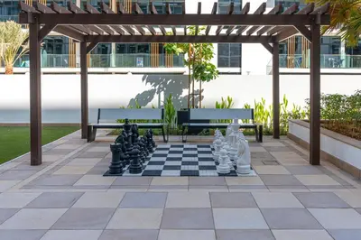 a chess board on a patio with two benches and a chess board at Upscale 1 Bedroom Apartment - Azizi Riviera 27 - Allsopp & Allsopp in Dubai