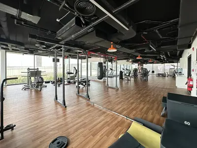 a gym with a wooden floor and treadmills at Golden Glow Getaway 1BR in JVC in Dubai