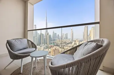 two chairs and a table in front of a large window at Luxury Stay Skyline Burj View in Dubai