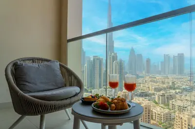 a table with a plate of food and two glasses of wine at Luxury Stay Skyline Burj View in Dubai