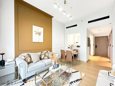 a living room with a couch and a table at Modern 1BR Haven in Prime JVC Spot in Dubai