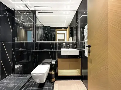 a bathroom with a white toilet and a sink at Modern 1BR Haven in Prime JVC Spot in Dubai