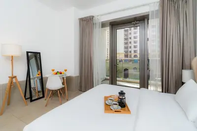 a living room with a white bed and a window at Cozy - Accessible to Tram - Convenient in Dubai